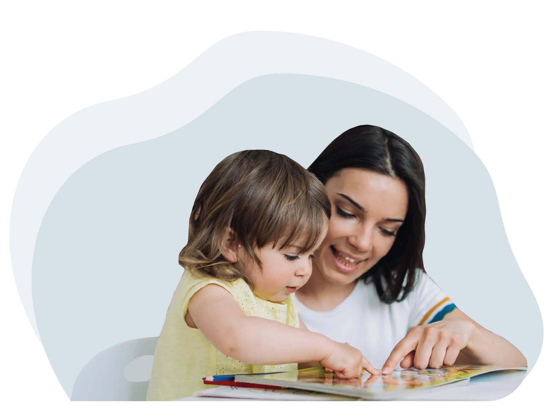 A nanny sits next to a child and together they are pointing at a book